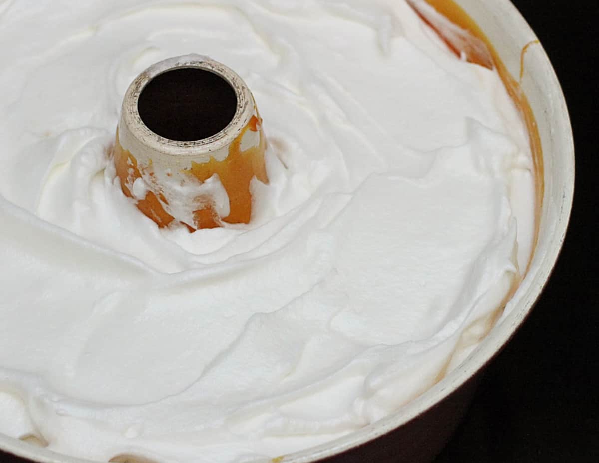 Meringue in a caramel coated tube pan ready to be baked.