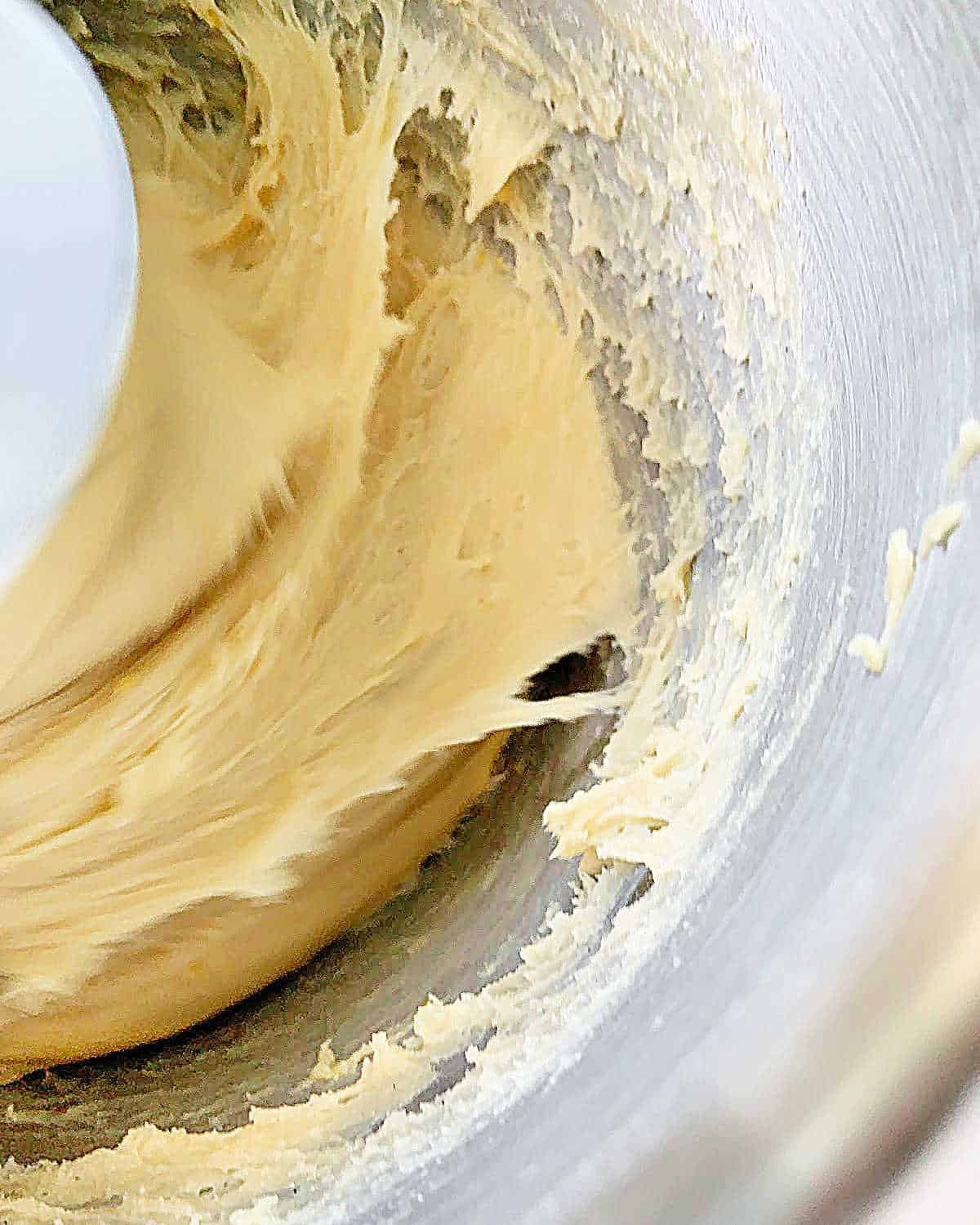 Kneading pandoro dough in a stand mixer bowl.