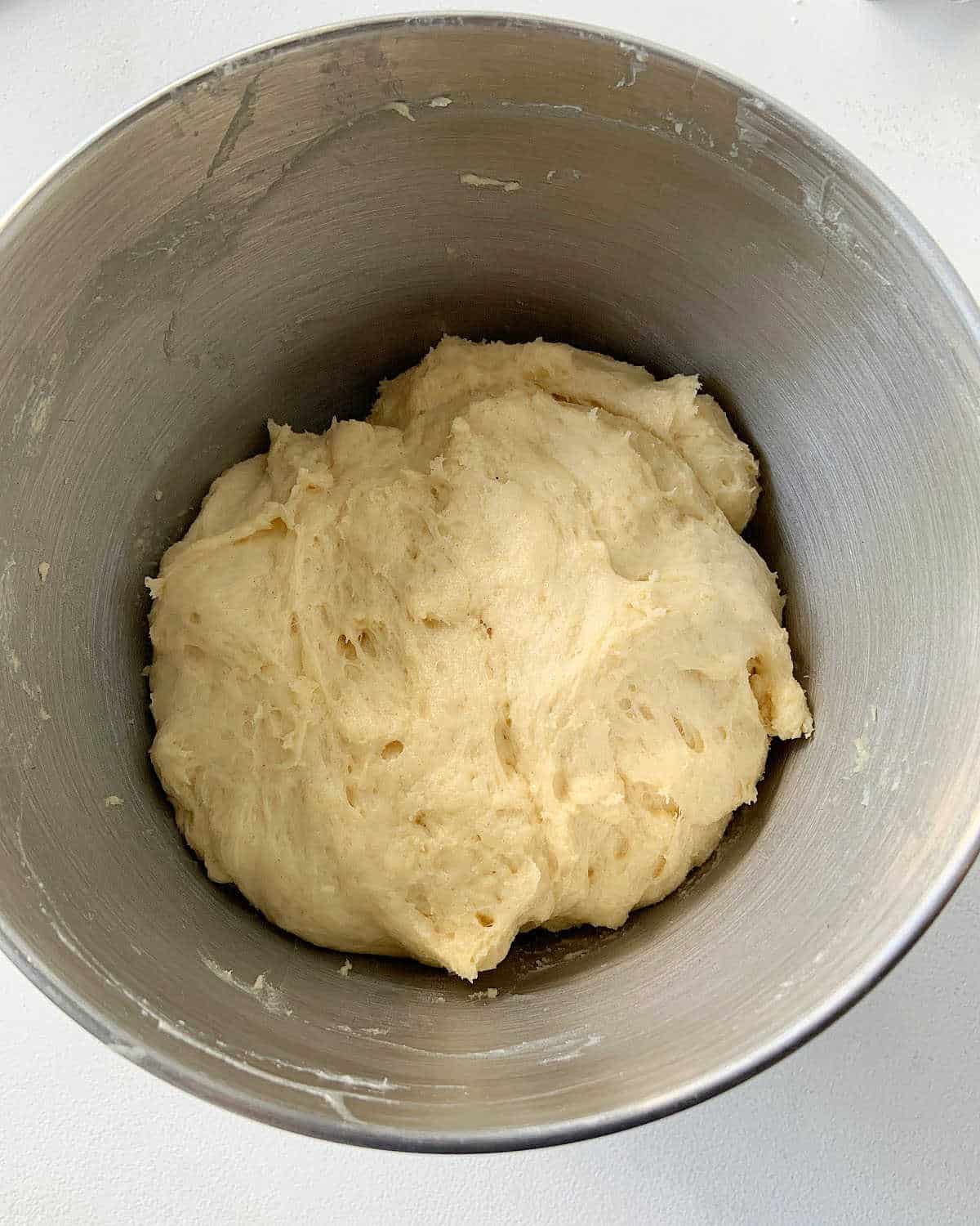 Top view of Pandoro dough inside a metal bowl.