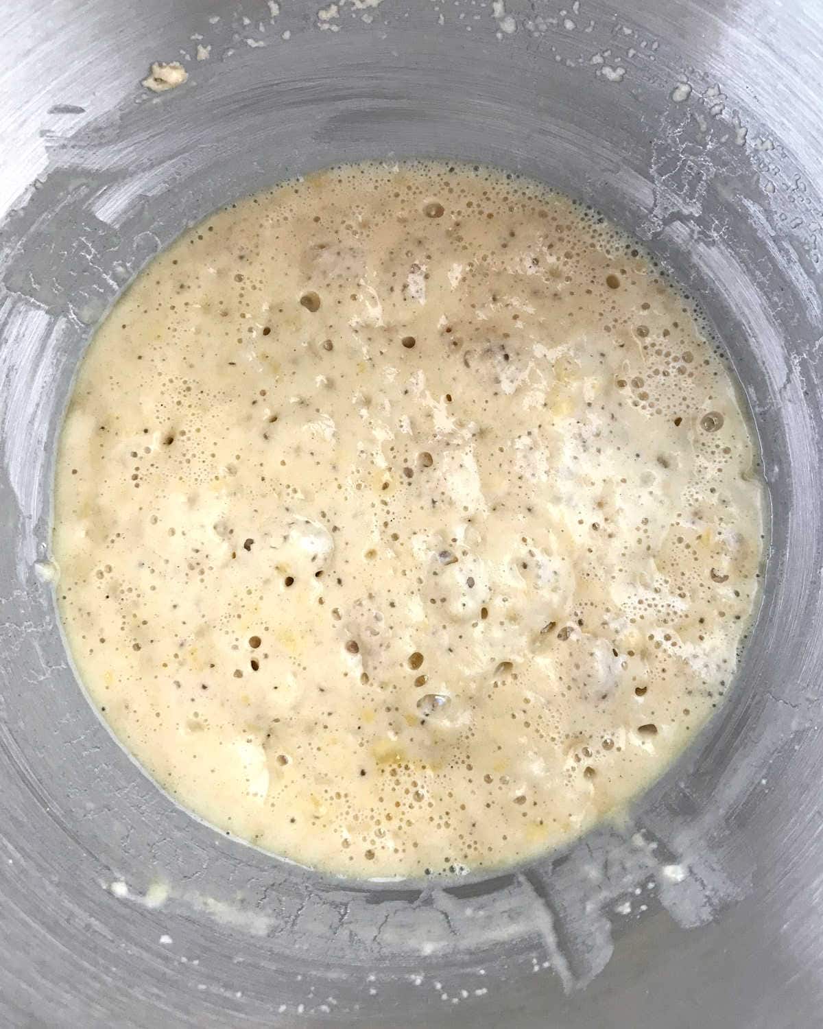 Bubbly yeast mixture in a metal bowl. Top view.