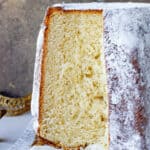 Pandoro bread with exposed crumb on white cloth and golden brown background