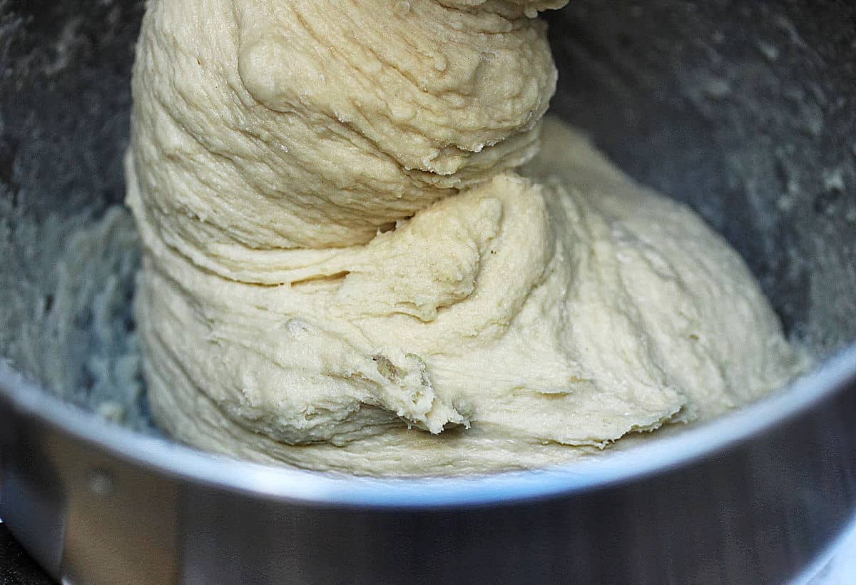 Bread dough in the making in the stand mixer's metal bowl.