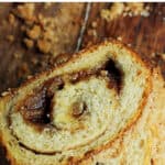 Overview of slices of cinnamon swirl bread on a wooden surface, crumbs around; red and brown text