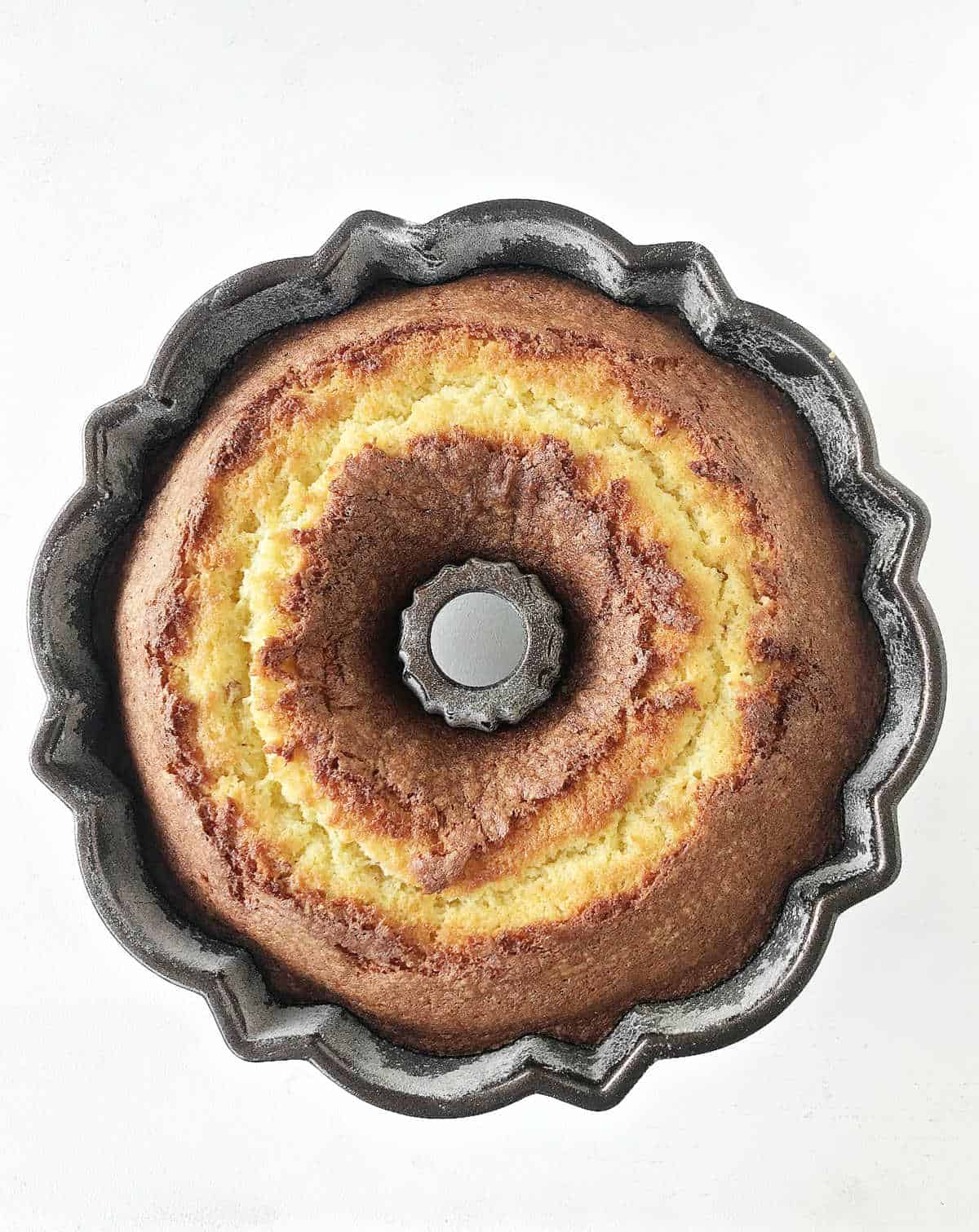 Baked lemon bundt cake in the pan. Top view. White background.