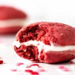 Close up of bitten red velvet whoopie pie. White background.