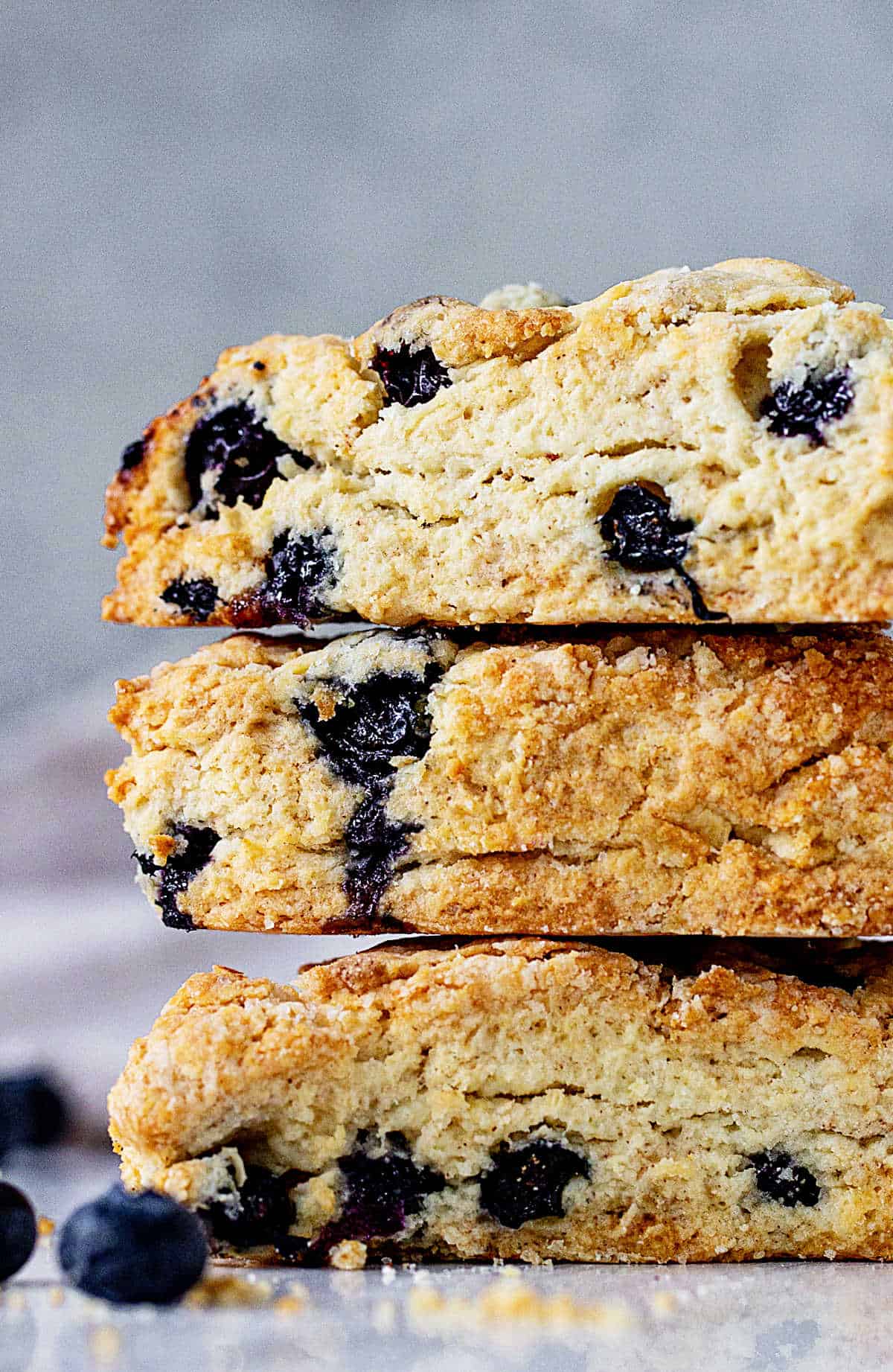 Very close up of partial stack of blueberry scones, grey blue background