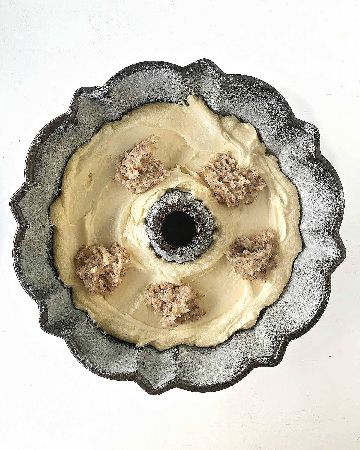 Top view of bundt cake with lemon cake batter and frangipane. White background.