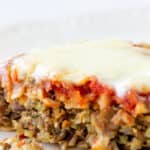Front view of eaten pizza-style veggie burger on a white surface