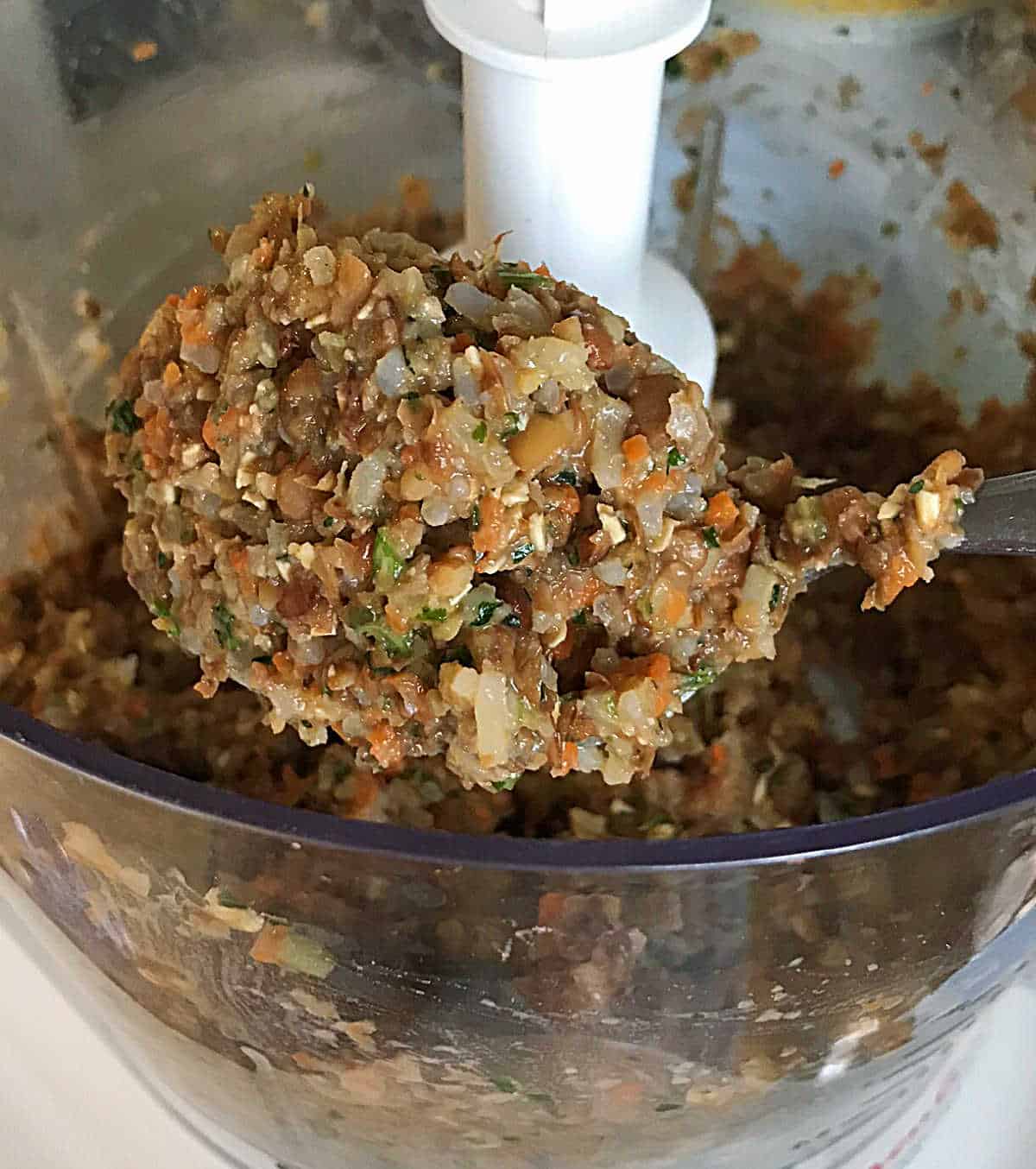 Thick scoop of lentil burger mixture on a spoon