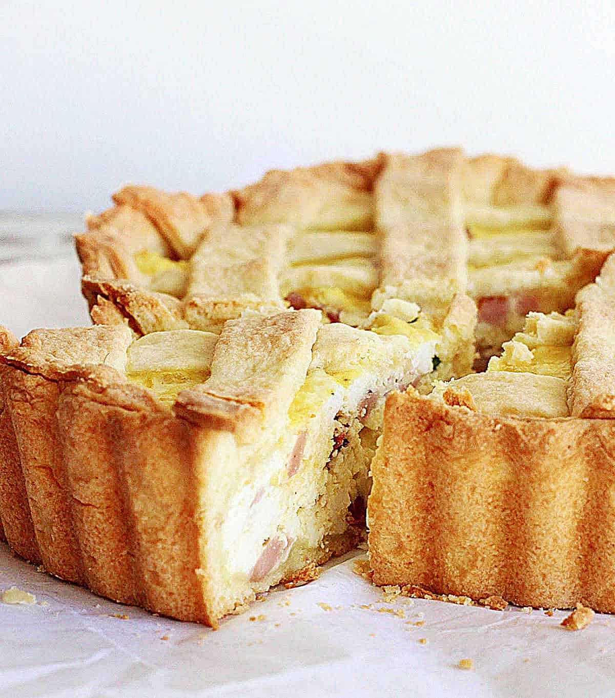 Close up of slice coming out of whole lattice savory ricotta pie