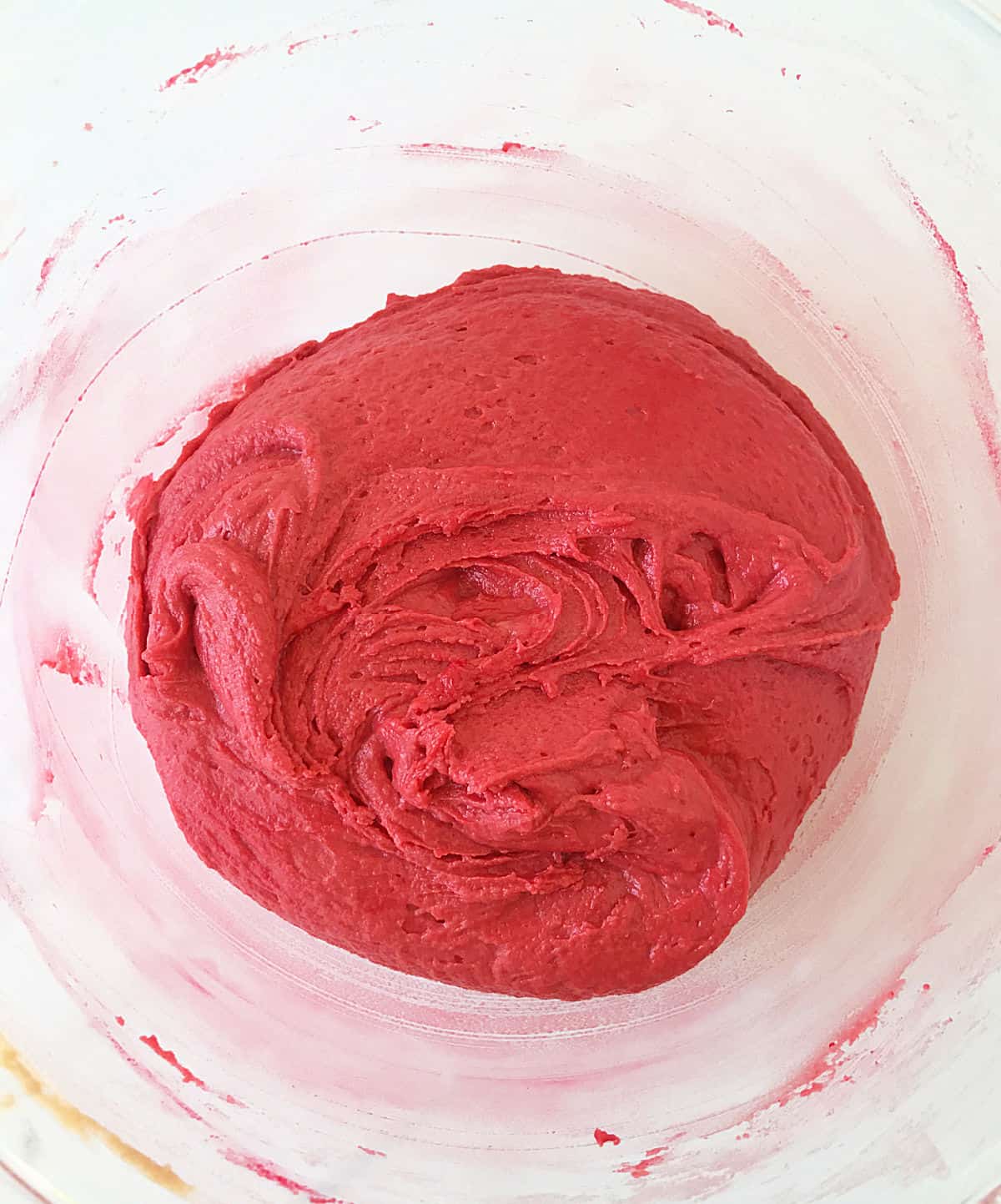 Red colored batter in a glass bowl