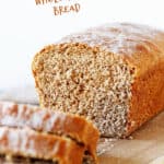 Partial loaf of sandwich bread and cut slices on long light colored wooden board, white background, brown text overlay