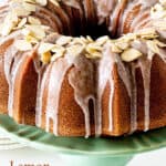 Close up view of glazed bundt cake with almond on green cake stand; brown text