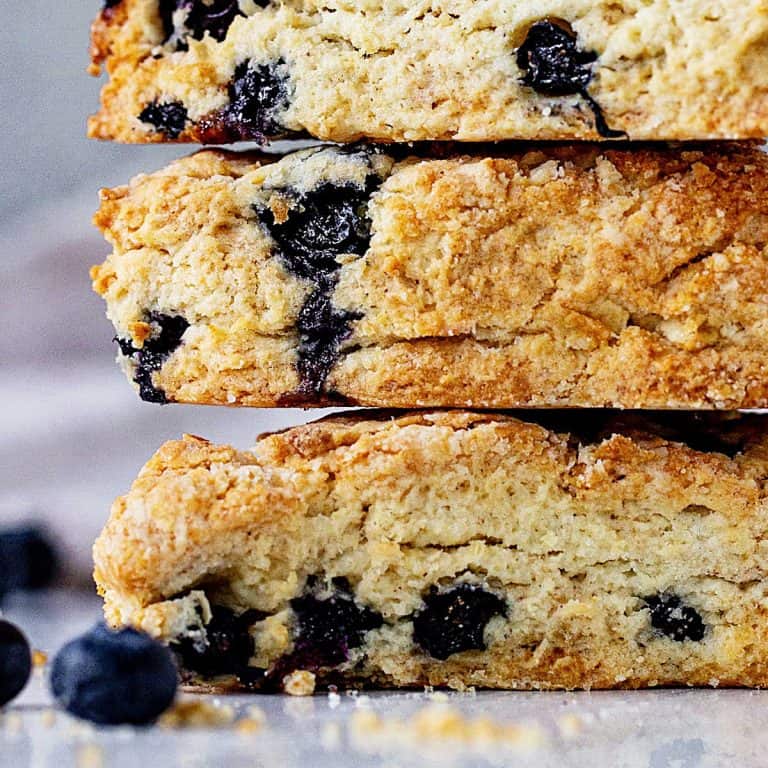 Close up of stack of blueberry scones with greyish background.