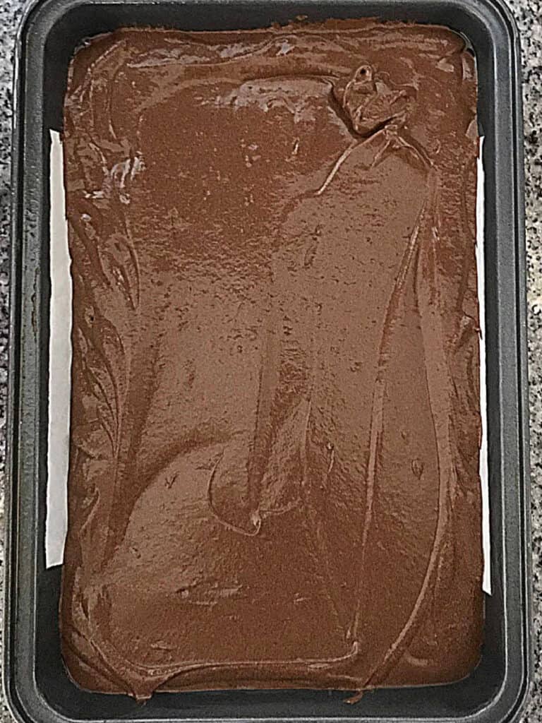 Top view of chocolate cake before baking in a metal rectangular pan.