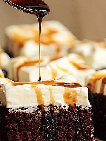 Stout syrup being poured over cream topped chocolate cake square