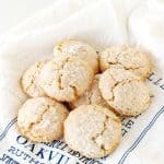 Several almond crinkled cookies on white and blue kitchen towel