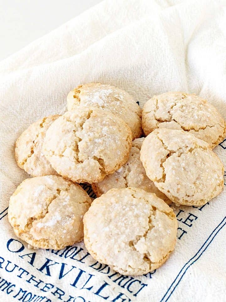 Several almond crinkled cookies on white and blue kitchen towel