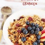 White bowl with granola and blueberries, whitish table and red text overlay