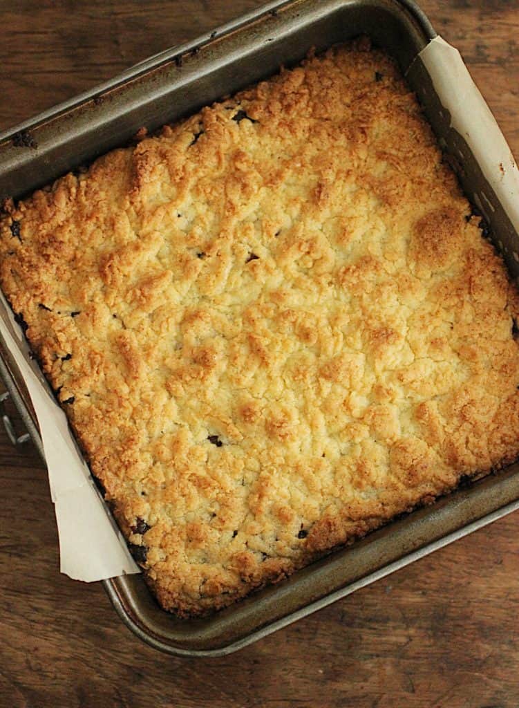 Baked shortbread on square metal pan on wooden table