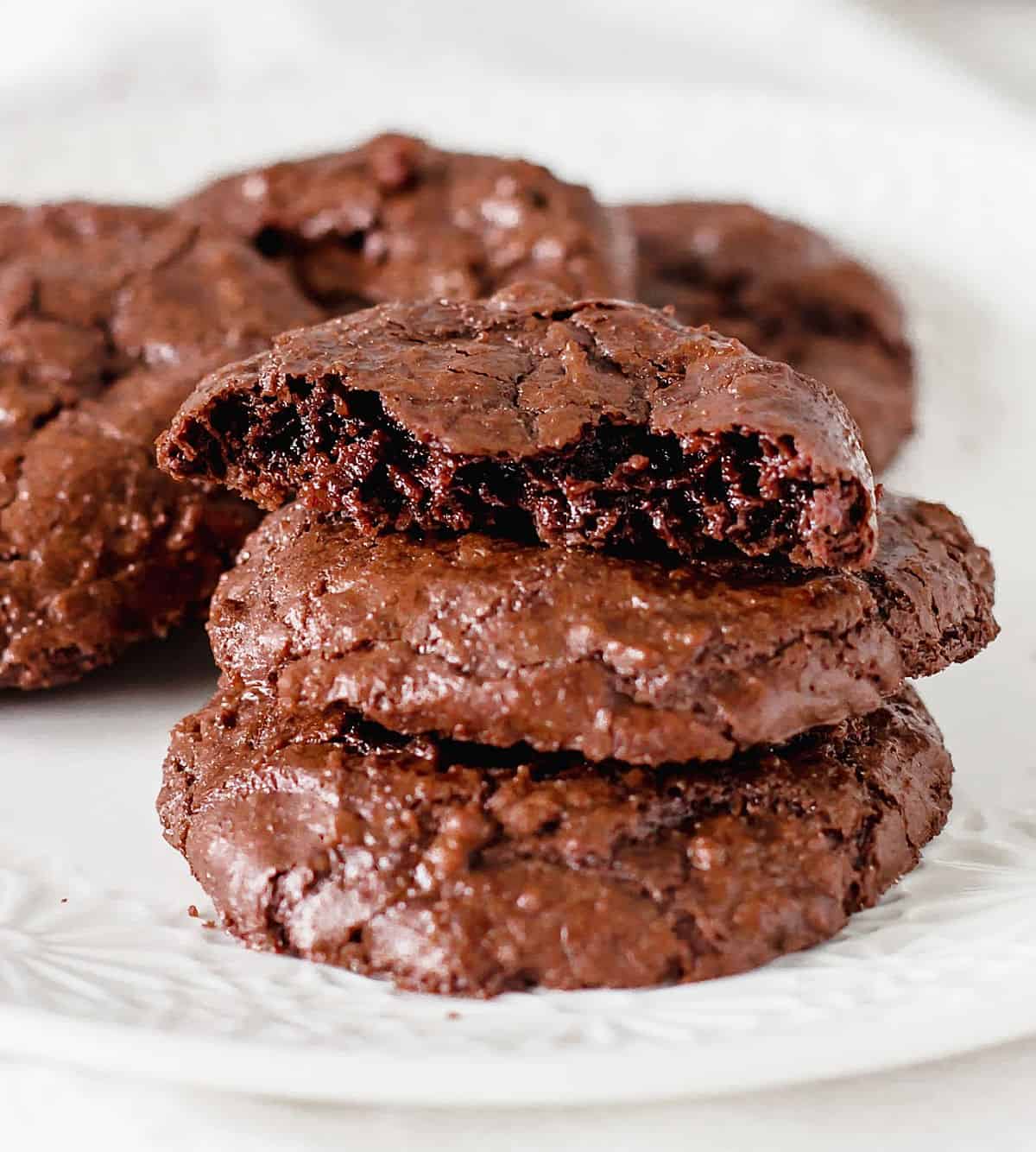 Close up or chocolate cookie stack with top one bitten, white background