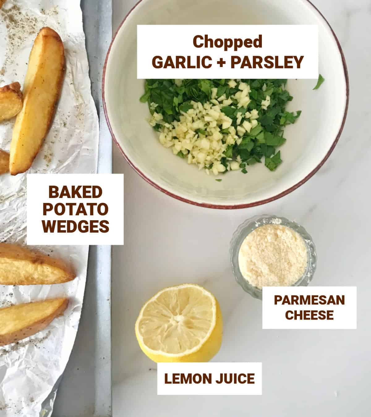Chopped garlic and parsley, parmesan in bowls, half a lemon, potato wedges, white surface.