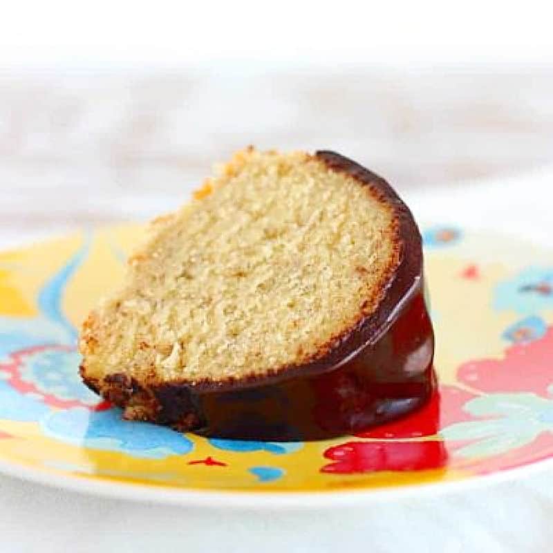 Colorful plate with slice of banana bundt cake with chocolate glaze.