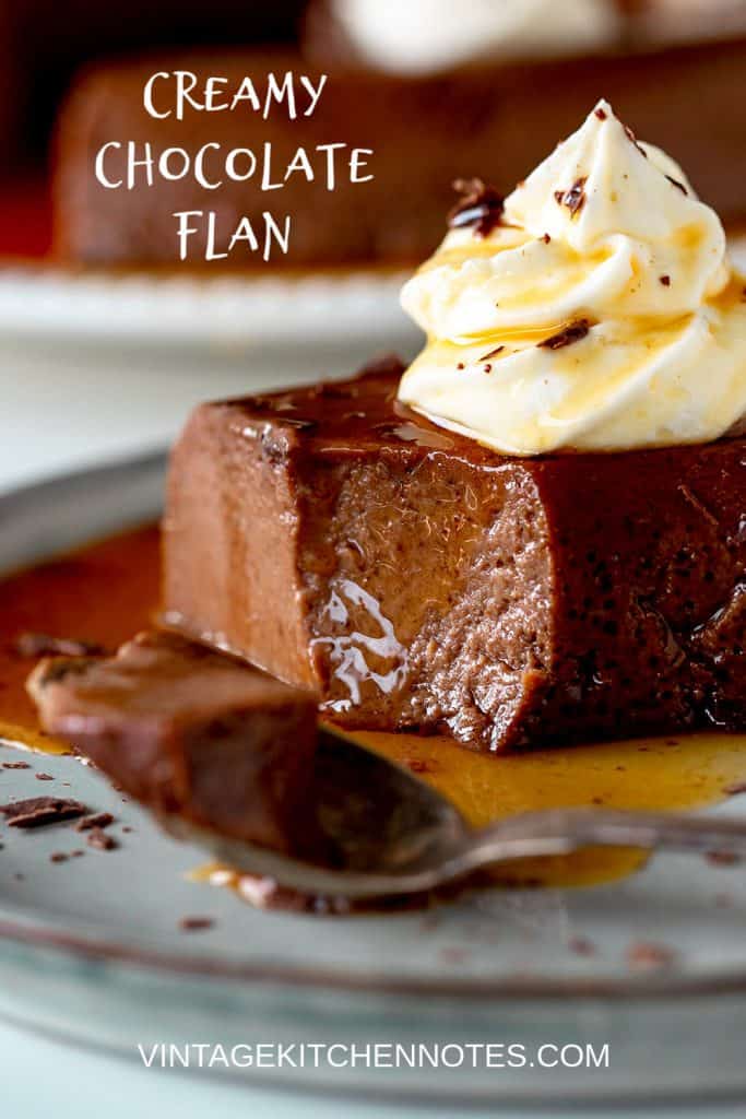 Close up of half eaten portion of chocolate flan with dollop of cream on grey plate; white text overlay