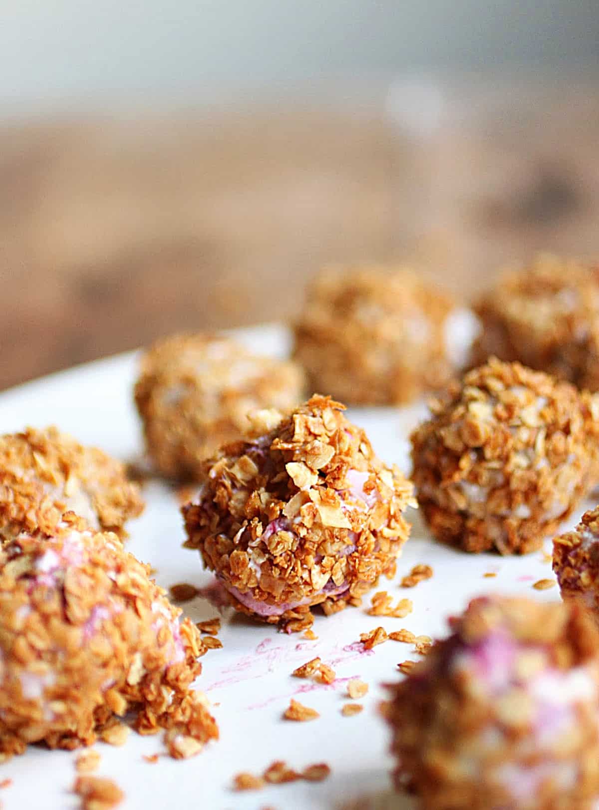 Ice cream truffles covered in granola on white plate