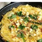 Close up of pasta frittata in cast iron skillet; red white text overlay