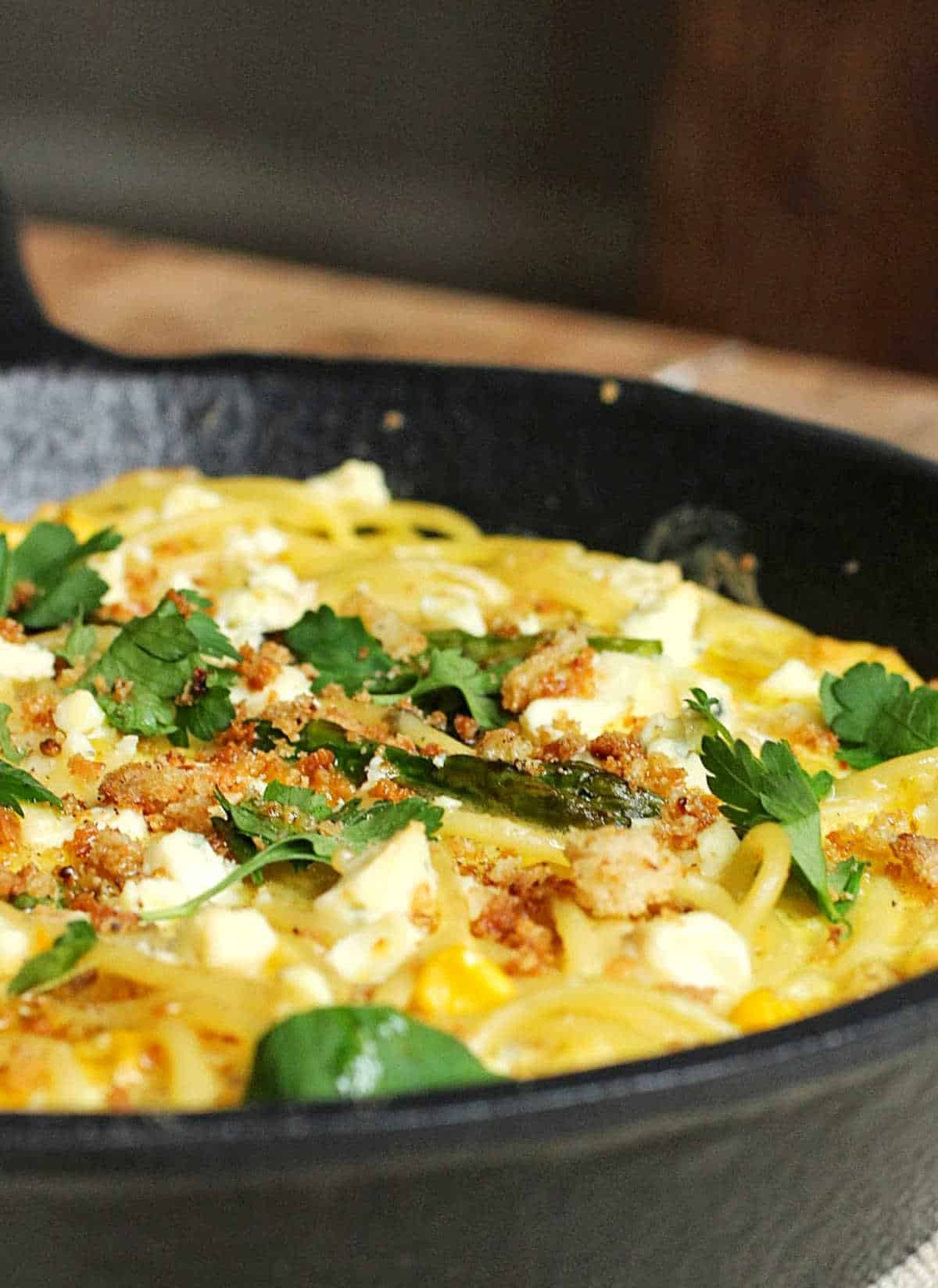 Surface view of parsley-topped frittata on a cast iron skillet.