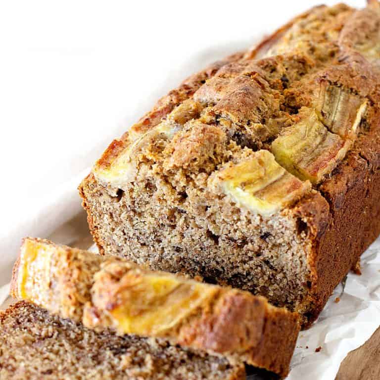 Sliced loaf of banana bread with a white background.