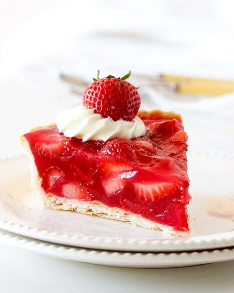 One slice of strawberry pie on two white plates