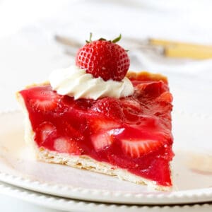 A slice of strawberry jello pie on a white plate. White background.