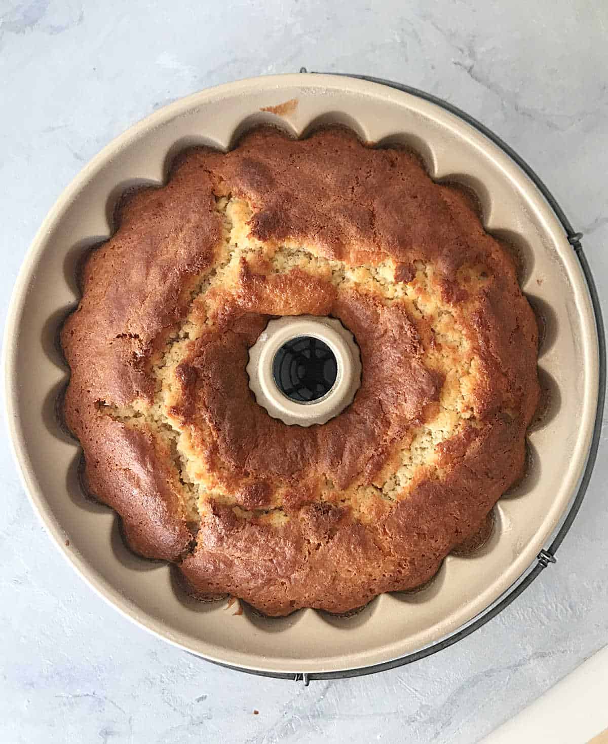 Baked cake in bundt pan on grey surface
