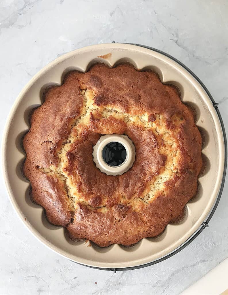 Baked bundt cake in the cake pan on a gray surface. Top view.