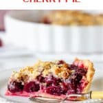 White plate with sigle cherry pie serving, a fork, pink napkin, white pie plate in background