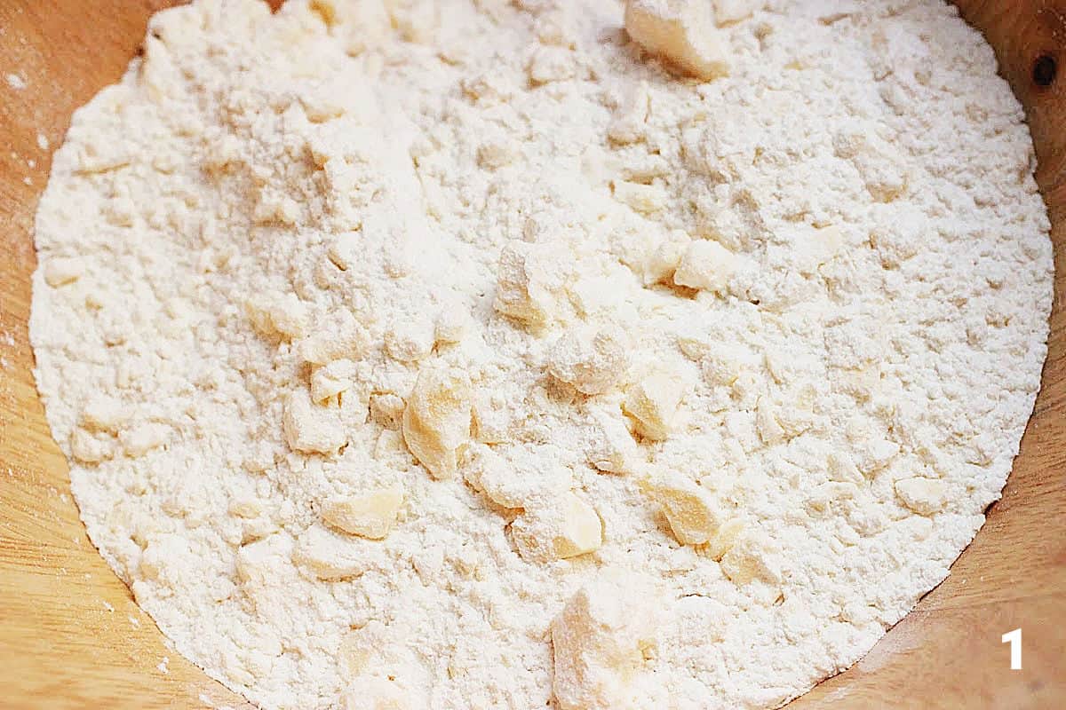 Flour with butter pieces in wooden bowl