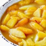 Peach pie filling in white bowl with brown rim.