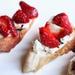 Very close up view of strawberry goat cheese tartine on white table