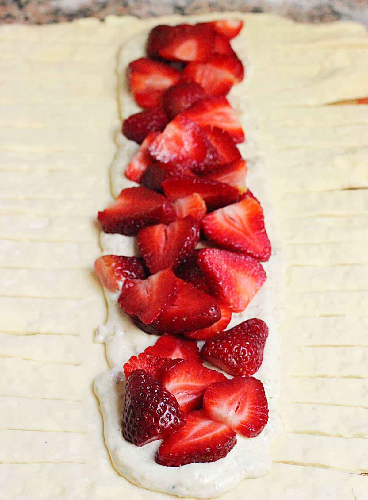 Open unbaked danish braid with strawberry filling