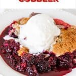 Serving of blackberry cobbler with ice cream on white plate; red text overlay