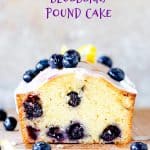 Cut pound cake with blueberries on wooden board and grey background with purple text overlay