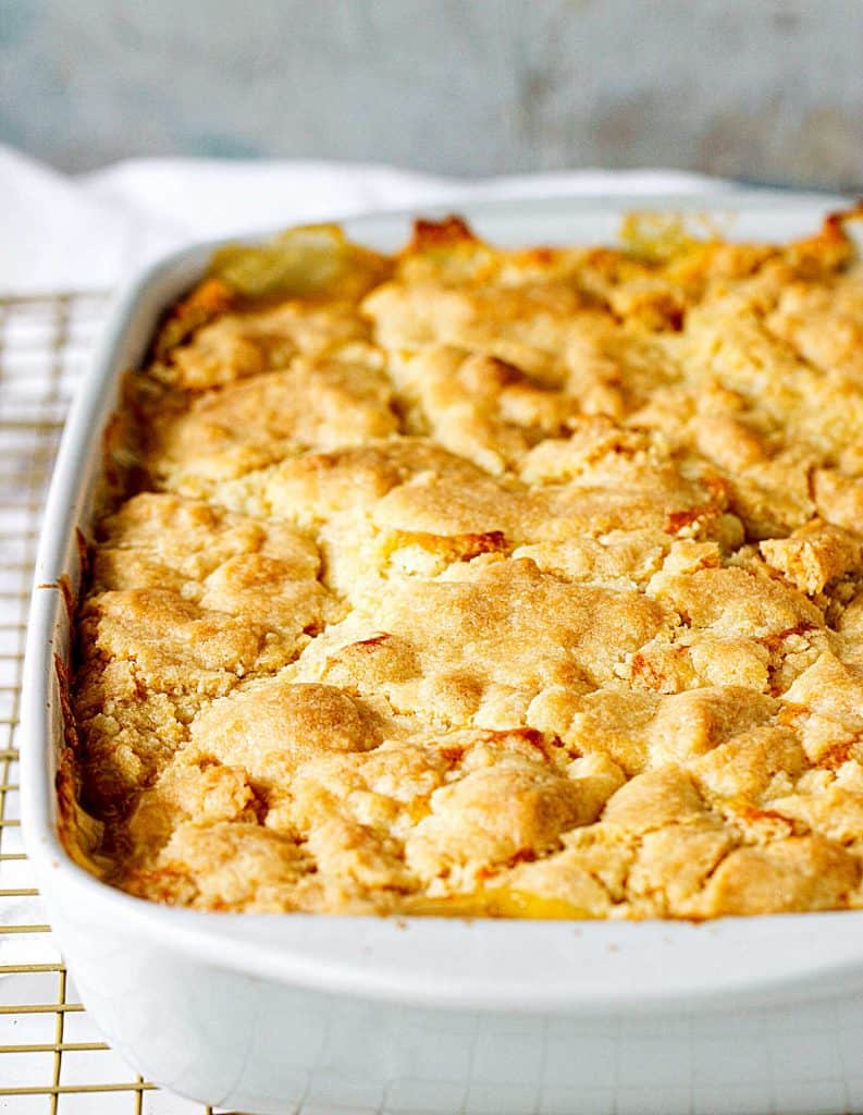 Whole baked peach cobbler in rectangular grey ceramic dish