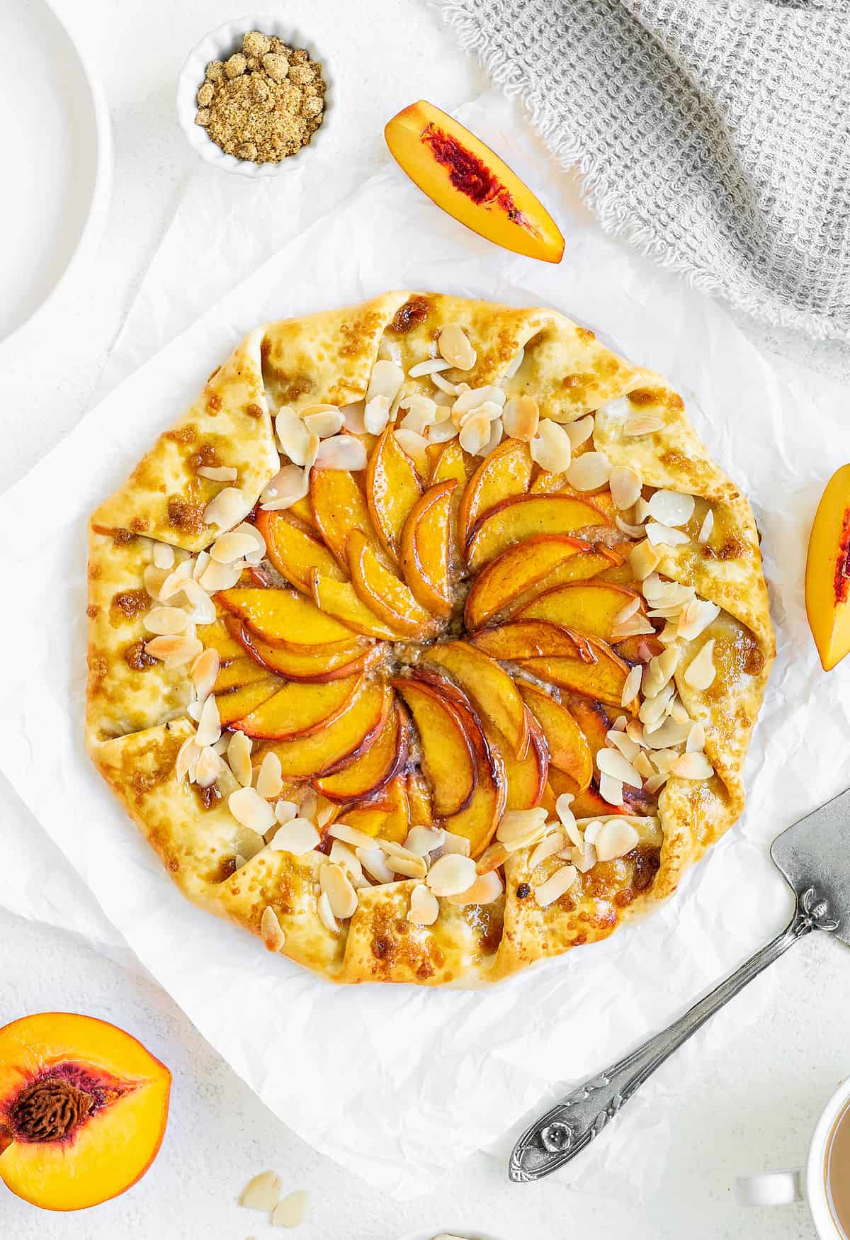 Whole peach galette on a white surface. Top view. Peach slices. 