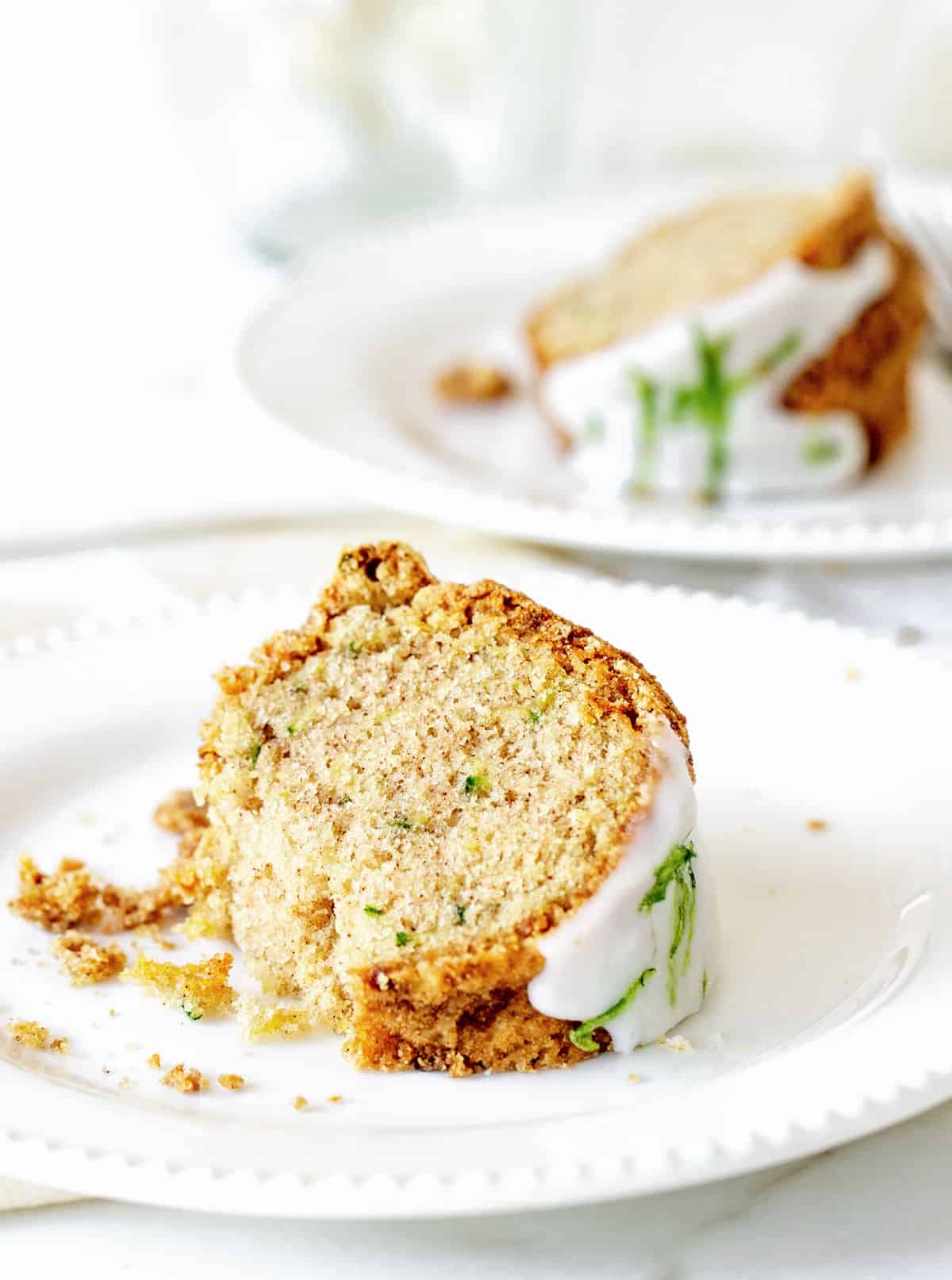 White plates with bundt cake slices on white background.