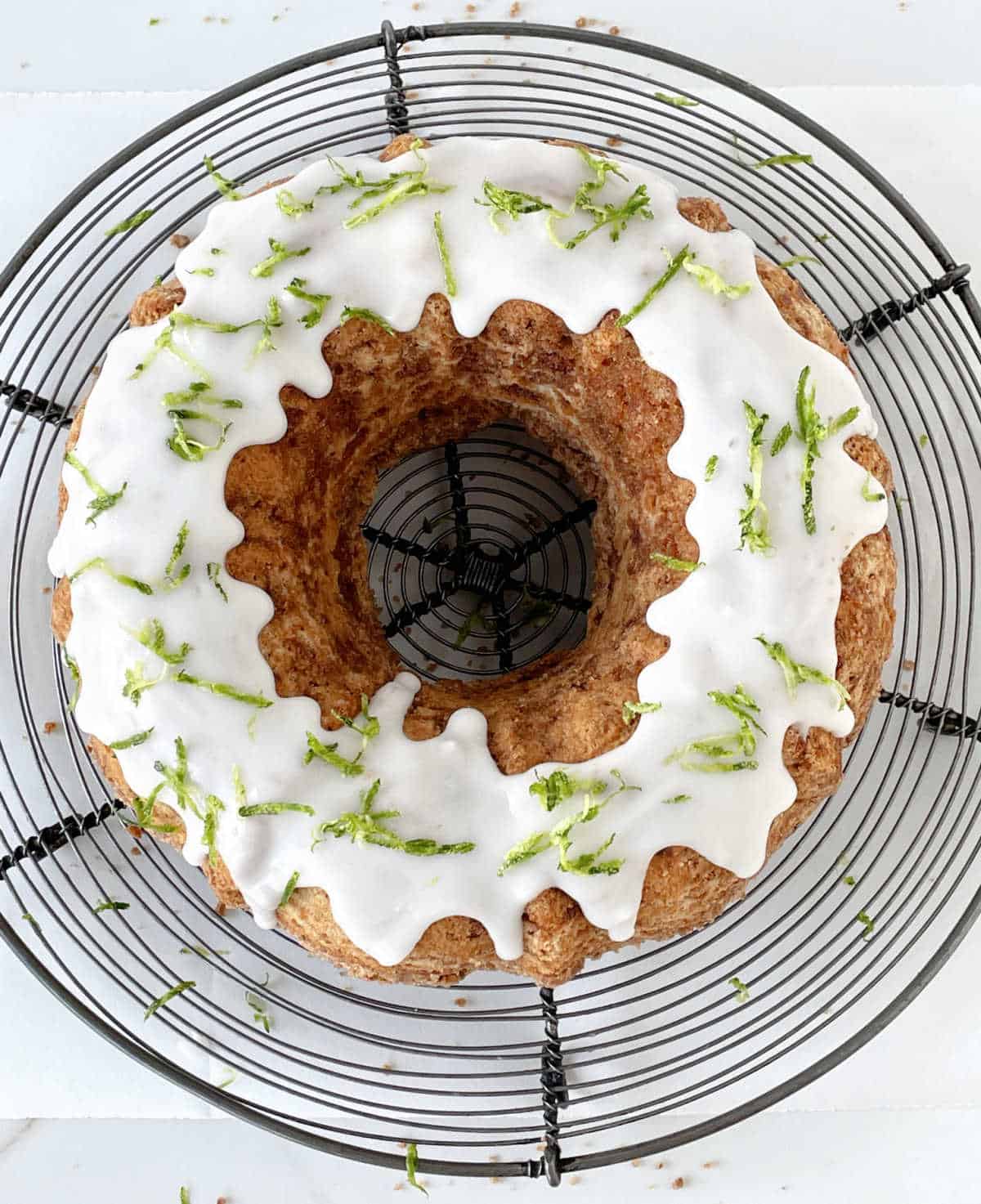 Whole glazed zucchini bundt cake on a wire rack. Top view.