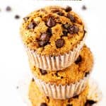 A stack of three muffins with chocolate chips in paper cups, white background, brown text overlay