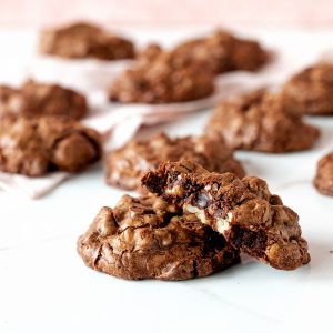 White and pink surface with chocolate walnut cookies, whole and half