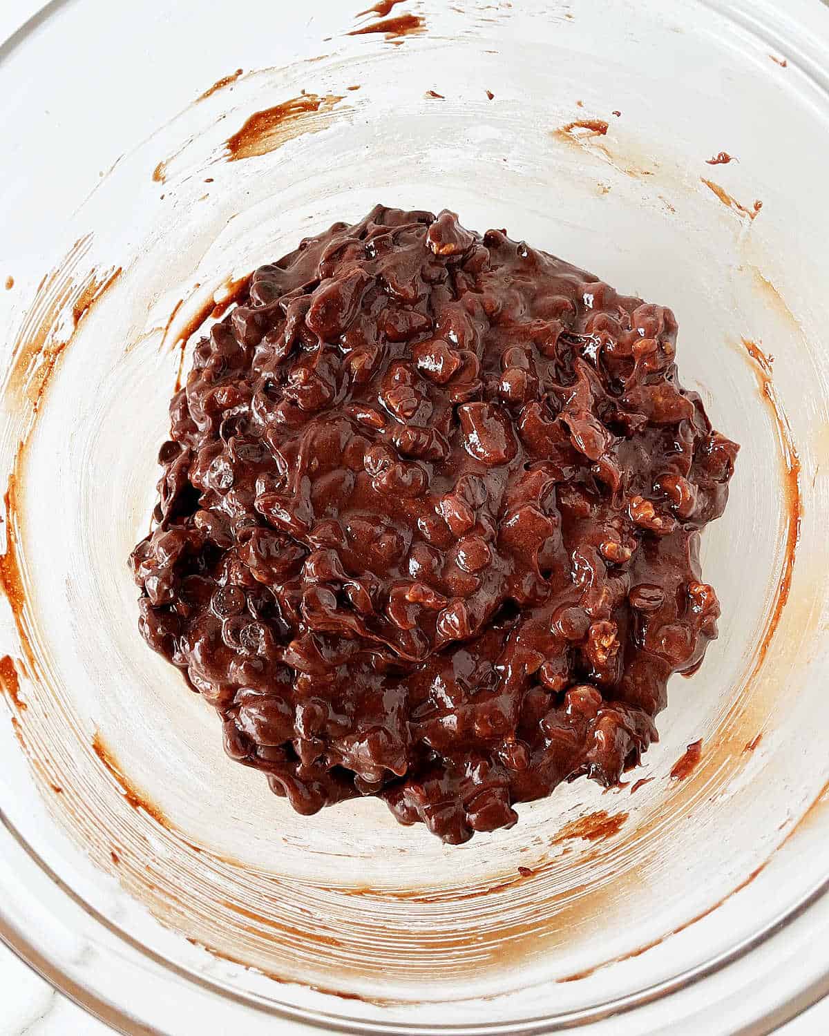 Walnut chocolate cookies mixture in a glass bowl. Top view.